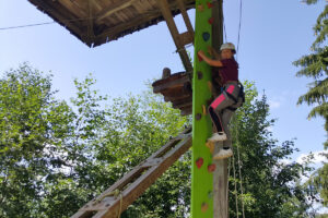 Der Haldenzipp startet gegenüber der künstlichen Boulderwand. Auch bei diesem Aufstieg ist man durch ein Höhensicherungsgerät von Skylotec bestens gesichert und klettert eine Kletterwand hinauf zur Plattform.